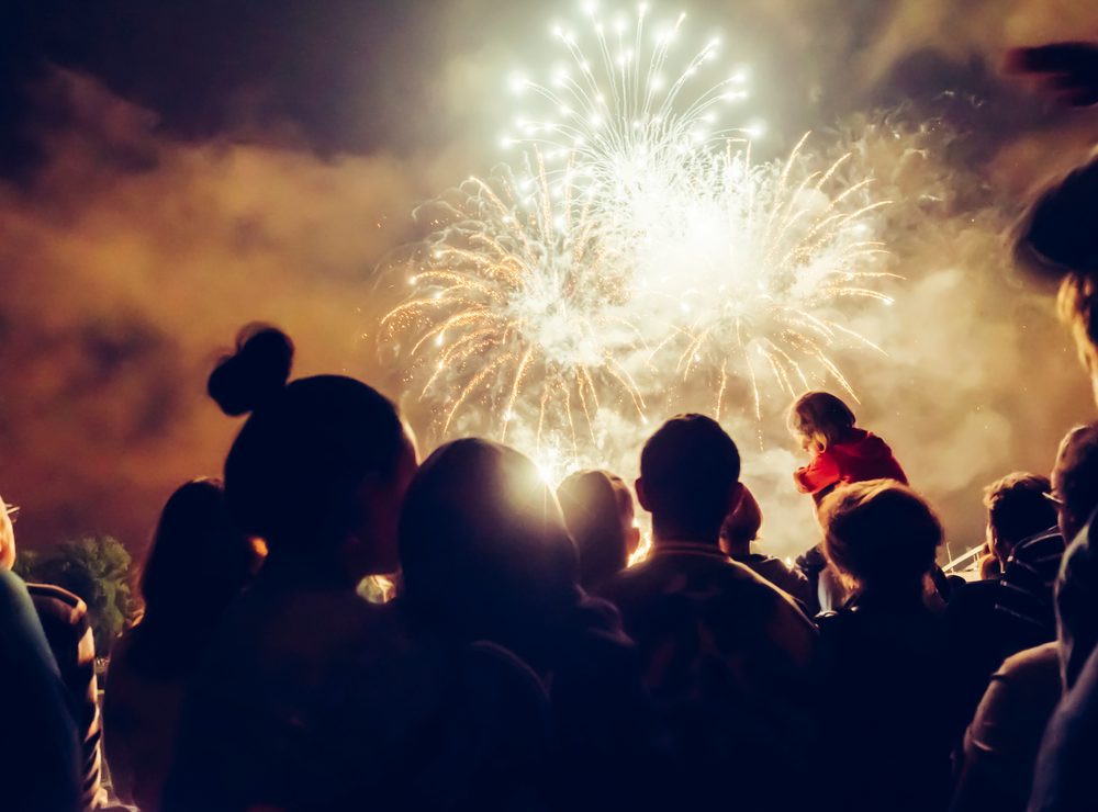 Audience silhouettes watching fireworks at a public display