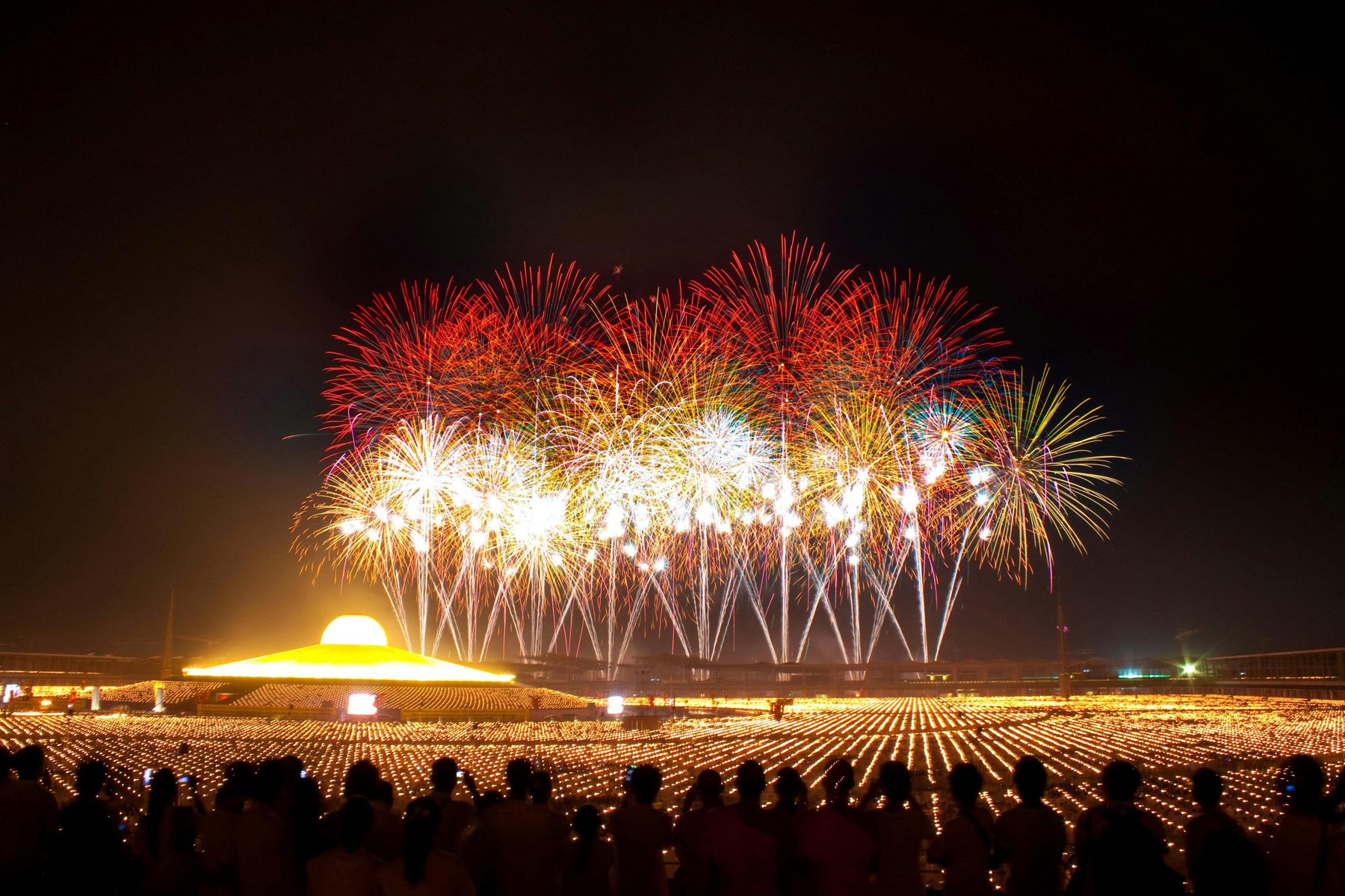 Firework finale over water with an audience watching