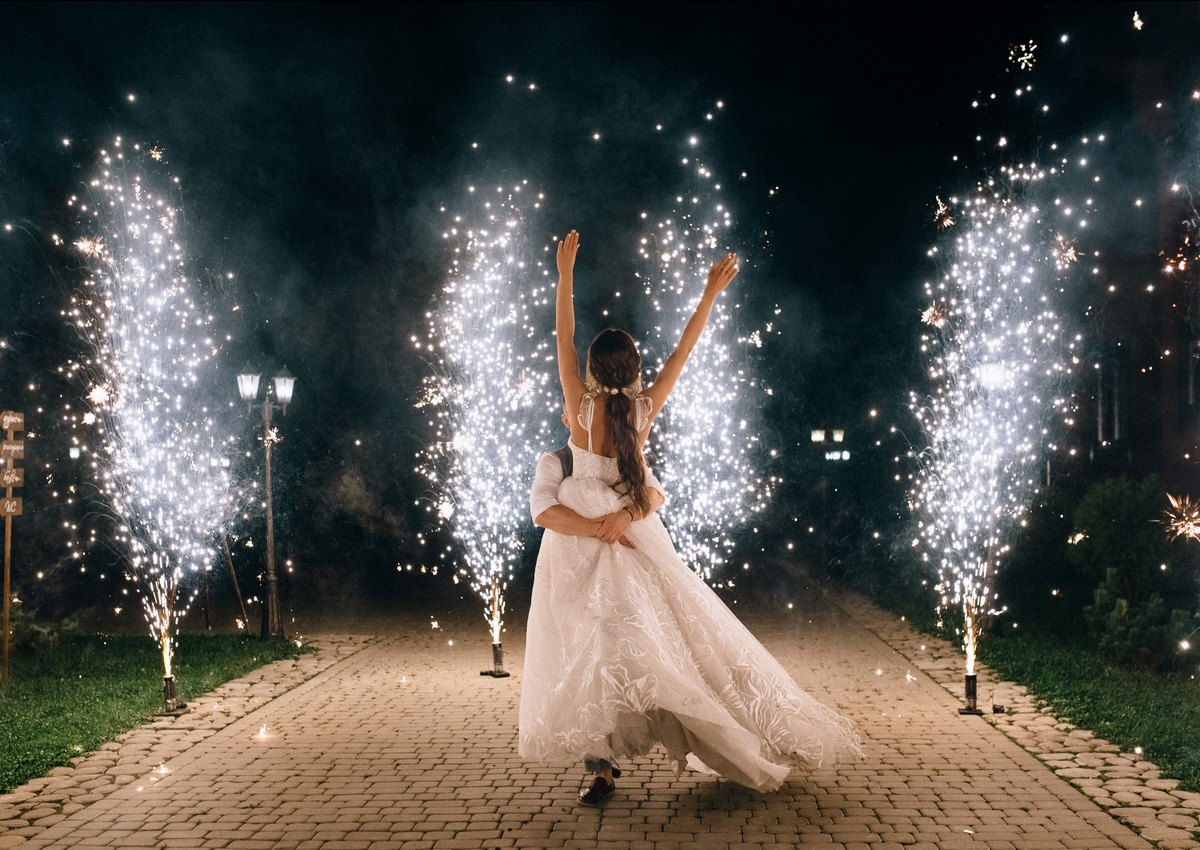 Bride walking through professional spark fountains at a wedding